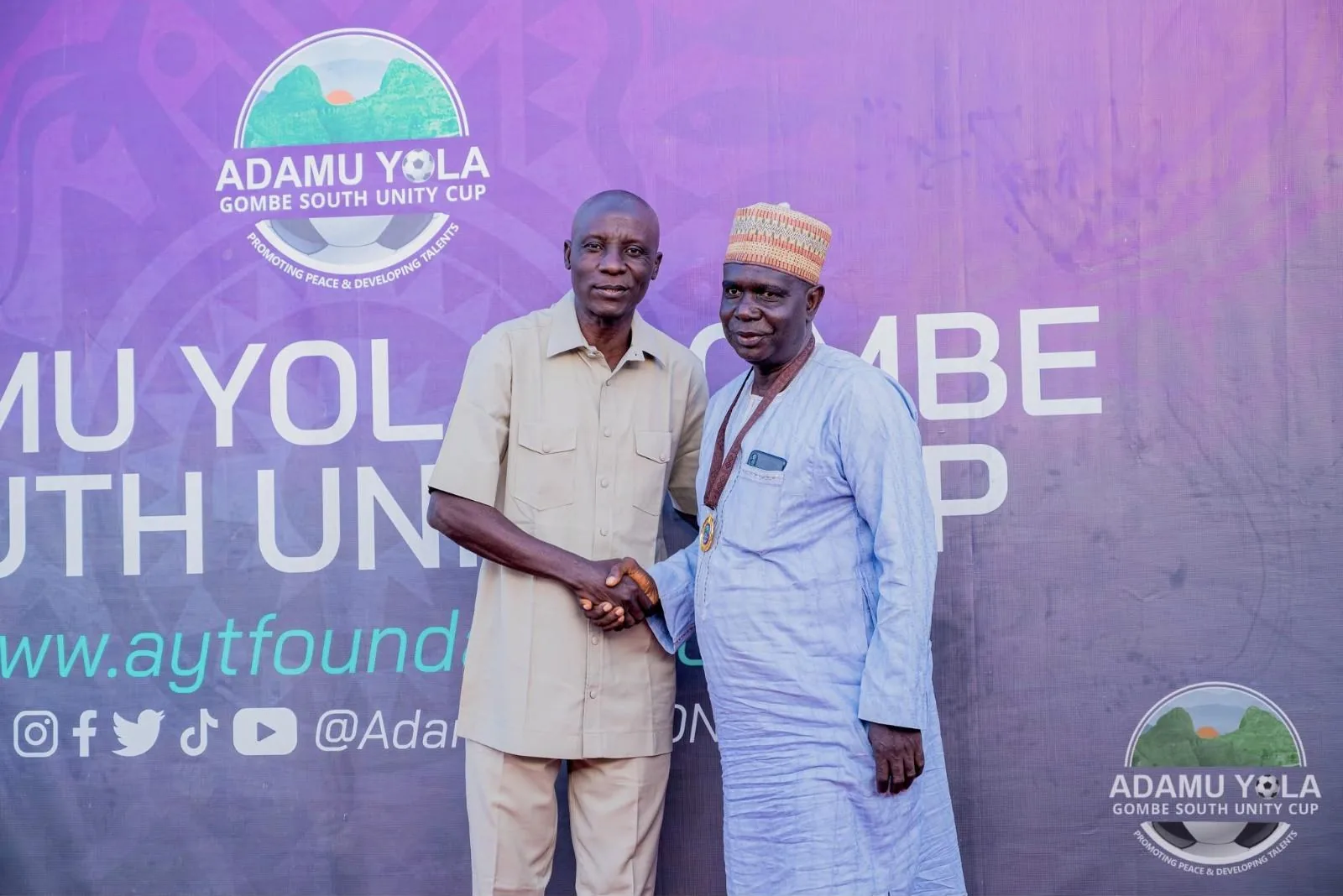 An official congratulates a community leader at the Unity Cup